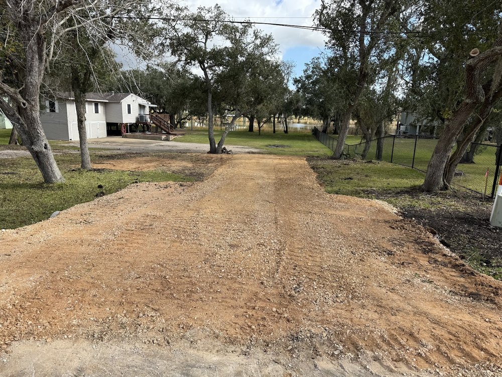 A fresh driveway cut through trees on a DBK Dirt Works job